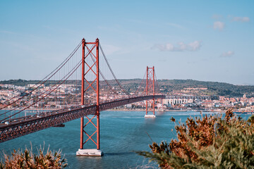 Beautiful landscape with suspension 25 April bridge bridge over the Tagus river in Lisbon, Portugal.
