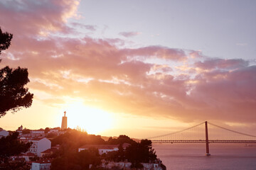 Beautiful landscape with suspension 25 April bridge bridge over the Tagus river in Lisbon at sunset.