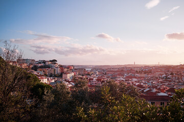 Fototapeta na wymiar Beutiful view of old town in Lisbon. Red tiled roofs and sunset sky.