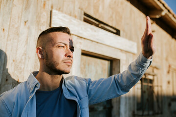 Man doing stop gesture while standing against wall