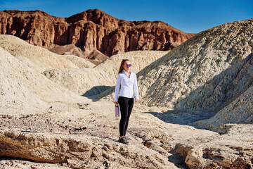 A family hike from Zabriskie Point in Death Valley national park in california. Huge sand dunes, terracotta mountains and hazy horizons are shining against clear blue sky in the midday sun.