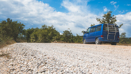 Fototapeta premium Camping adventure in the wilderness: Minivan is standing at the side of the desert road