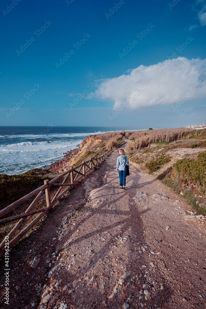 Wall mural Tourism concept. Young traveling woman enjoying ocean view.