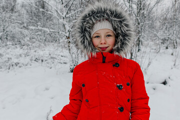 Smiling girl in warm clothing standing at forest during vacations