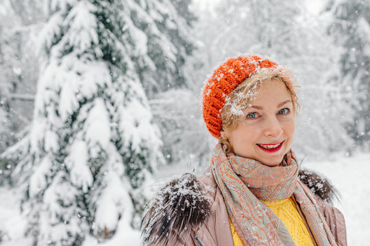 Mature Woman Smiling While Standing In Forest During Winter