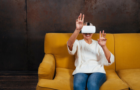 Senior woman enjoying virtual reality while sitting on sofa