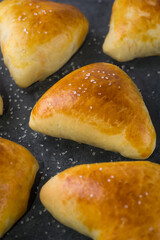 fresh, baked sugar buns on a dark surface, sugar sprinkled on top