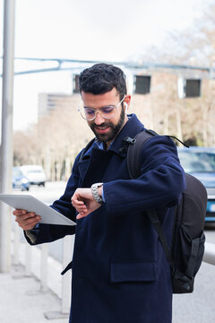 Male business professional with digital tablet checking time