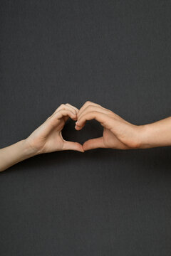 Studio shot of male and female hand making heart shape