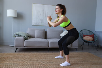 Fototapeta na wymiar Young woman doing sports exercises at home