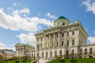 panoramic view of the white historical palace of the Peshkov House and passing cars against the background of a cloudy sky on a spring day. Concept-a famous place in Moscow Russia