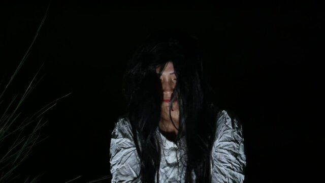 Portrait of asian woman make up ghost face,Horror scene movie,Scary background,Halloween poster,Haunted spirits from the dead in the night.