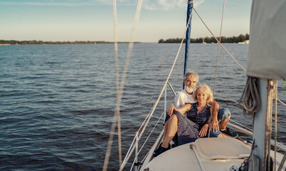 Romantic vacation and luxury travel. Senior loving couple sitting on the yacht deck. Sailing the river.