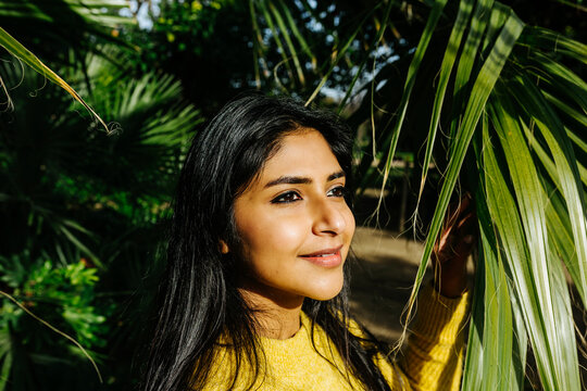 Beautiful Smiling Woman Looking Away By Tree In Park