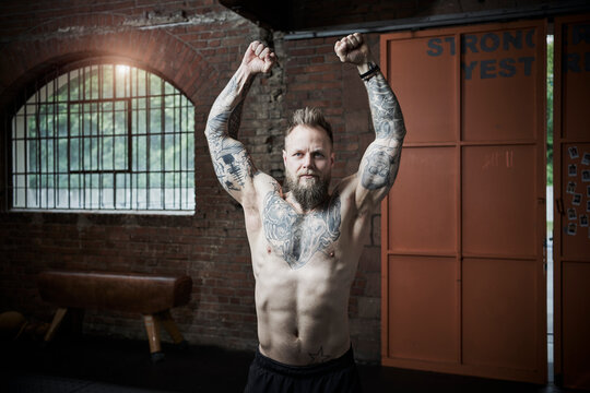 Active male athlete clenching fist while exercising in gym