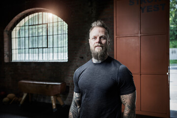 Confident male fitness trainer at gym