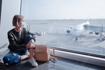 New normal and social distance concept. Young woman tourist wearing face mask during corona virus 2019 outbreak at airport.
