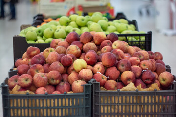 Boxes of juicy apples in the supermarket. Photo on the theme of fruit.
