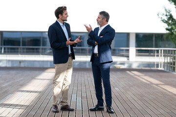 Business people having discussion while standing on office building terrace
