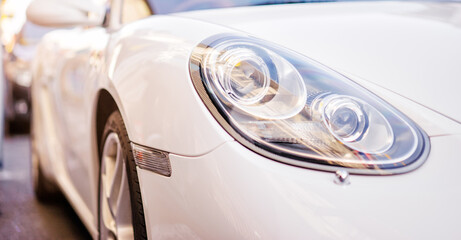 Headlights. Close up of white car.