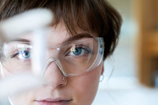 Close-up of female technician wearing eyeglasses working while standing in laboratory