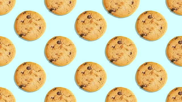 Stop Motion Animation. Whole round American cookies with chocolate pieces in a pattern are pressed randomly in the form of a button