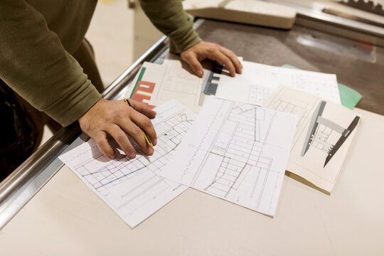 Male design professional working with craft design on paper standing at workbench in industry