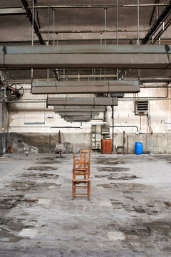 Empty wooden chairs in abandoned factory