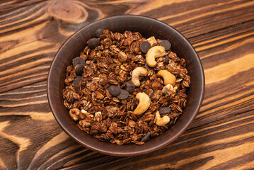Chocolate granola cereal with nuts in a bowl.