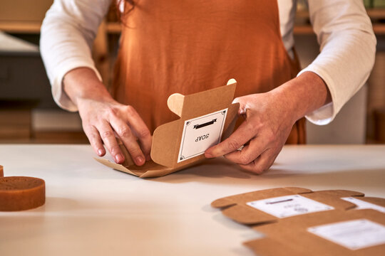 Woman packing handmade soap in boxes at workshop