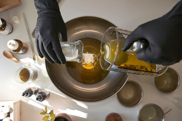 Woman mixing ingredients in steel bowl while making soap in workshop