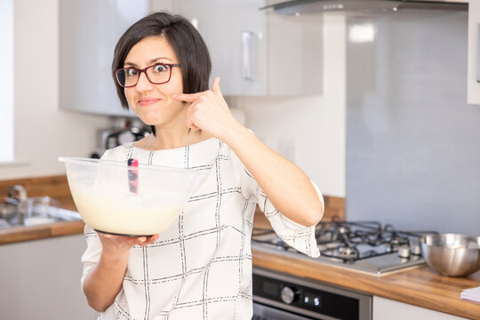 Woman Preparing Cheesecake Filling And Making Hand Gesture To Say It Is Delicious