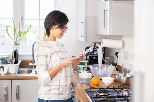 Woman reading a recipe before baking cake at home