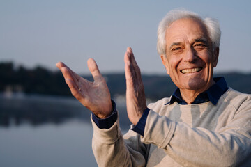 Cheerful man clapping while standing outdoors