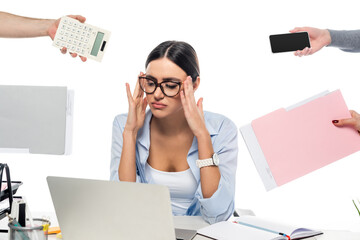 exhausted businesswoman touching head at workplace near people with documents isolated on white.