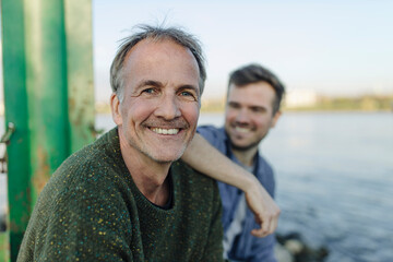 Happy father by son against river