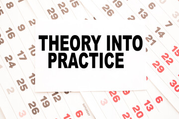 Notepad with text THEORY INTO PRACTICE on the office desk with stationery. A blank notepad for...