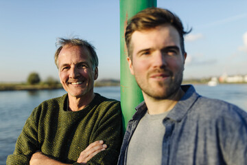 Happy father and son against river