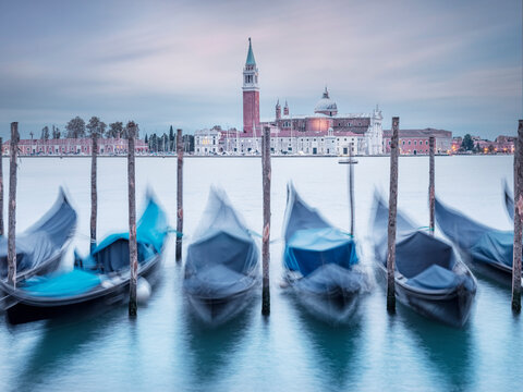 Italy, Veneto, Venice, Long exposure of gondolas moored in front of San Giorgio Maggiore island