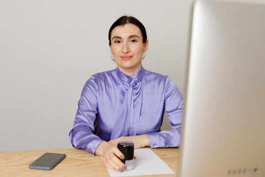 Businesswoman holding rubber stamp while sitting at table in home office