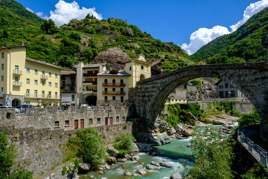 Italy, Pont-Saint-Martin, Town in Aosta Valley with Roman arch bridge stretching over river Lys in foreground