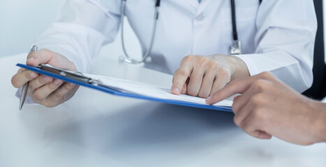 Doctors hand pointing health examination results report and recommend medication to patients.