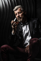 Portrait of a gentleman observing his glass of alcohol