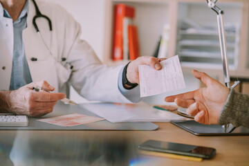 Doctor giving prescription to patient at doctor's office