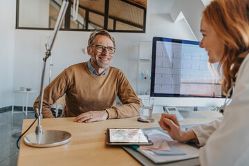 General practitioner smiling at male patient in clinic