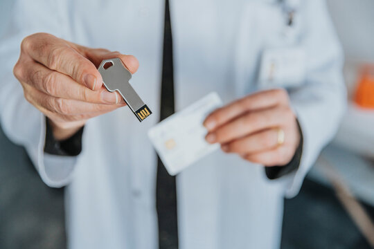 Male doctor holding USB stick while standing at clinic