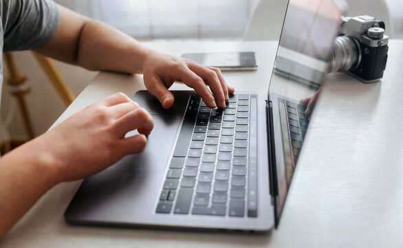 Man using laptop by digital camera at home office