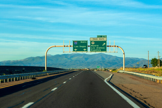 Road sign on highway against blue sky