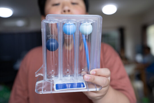 Fat boy uses a Tri-ball Incentive Spirometer for check his lung function.