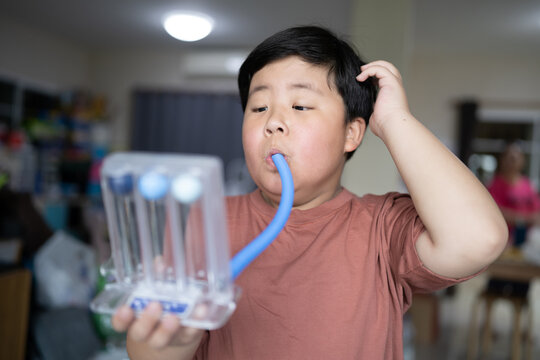 Fat boy uses a Tri-ball Incentive Spirometer for check his lung function.